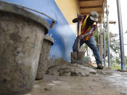 A construction workers mixes cement on February 5 to repair a section of the Lacovia Primary School in St Elizabeth that was damaged during the passage of Hurricane Melissa last October.