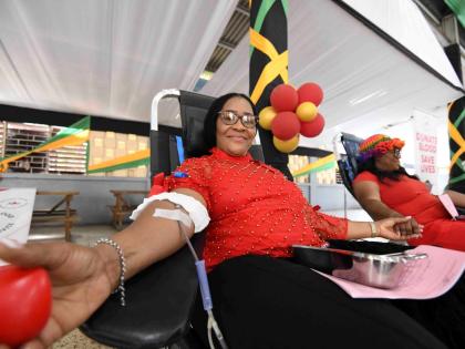 Sonya Binns-Lawrence, Jamaica’s top female blood donor, gives blood during her birthday blood drive, held on the grounds of Kencot Seventh-day Adventist Church in Kingston yesterday. 