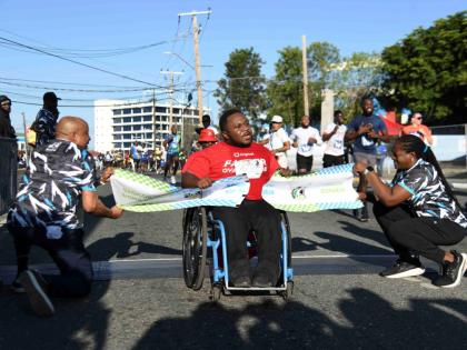 Finishing first in his division, Marcus Banton happily wheels across the finish line on Sunday at the annual Sigma Corporate Run.
