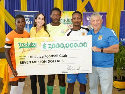 Lauren Mahfood, marketing manager at Trade Winds Citrus Limited (second left), and Peter McConnell, managing director of Trade Winds Citrus Limited (right), share a moment with members of the Tru Juice Football Club following the formal handover of $7 mill