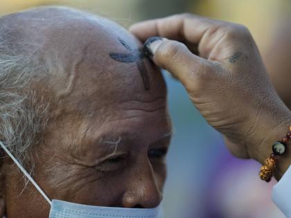 A lay minister places ash on the forehead of a devotee during Ash Wednesday outside a church in downtown Manila, Philippines. 