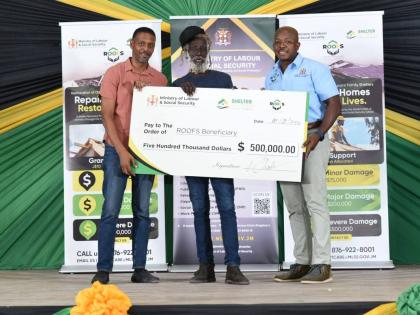 Chensie Allen (centre) accepting a symbolic cheque valued at $500,000 from the Ministry of Labour and Social Security’s ROOFS Programme. Presenting the cheque were Dwayne Vaz, member of parliament for Westmoreland Central (left), and Pearnell Charles Jr,