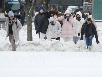 Pedestrians climb over snow banks to try and cross the streets in New York, Monday, January 26, 2026. (AP Photo/Seth Wenig, File)