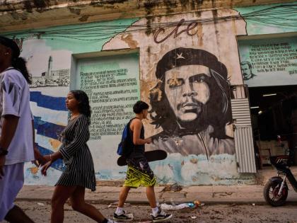 People walk past a mural of Che Guevara in Havana.