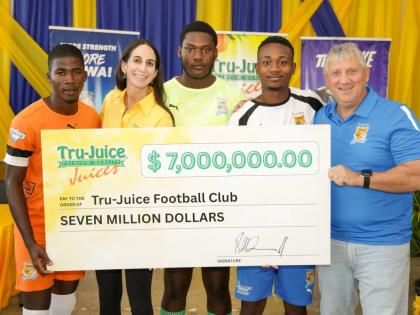 Lauren Mahfood (second left), marketing manager at Trade Winds Citrus Limited, and Peter McConnell (right), managing director of Trade Winds Citrus Limited, share a moment with members of the Tru-Juice Football Club following the formal handover of a $7-mi