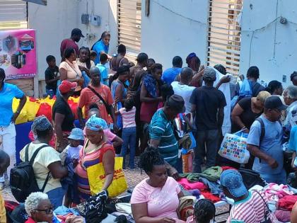 Janet Richards (left), the founder of the Janet Richards Foundation, looks on as residents of Chatham, St James, congregate at the grounds of the Bethtephil Baptist Church in the community for the distribution of care packages by the foundation last Saturd