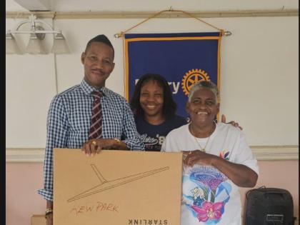 Ramon Bremmer (left), the principal of Kew Park Primary School, accepts a Starlink package from  Rotary president Jean Powell. Looking on at centre is Tracie Campbell, the principal of Ferris Primary School.