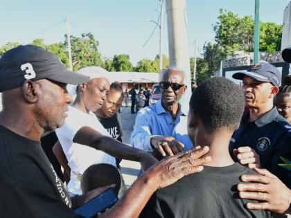 Minister of Local Government and Community Development and Member of Parliament for West Kingston,Desmond McKenzie (centre), offers words of comfort to Jayce Pinnock's mother, Ladania Cunningham (second left) and other relatives, during a visit with the fa