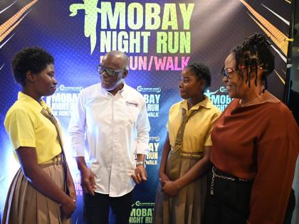 
From left: Tanesia Gordon, student, Anchovy High School, in conversation with Howard Ward, chairman of the MoBay Night Run 5K Run/Walk, while Tianna Nolan, Anchovy High School student and Dr Lavern Stewart, principal of Anchovy High, react during the offi