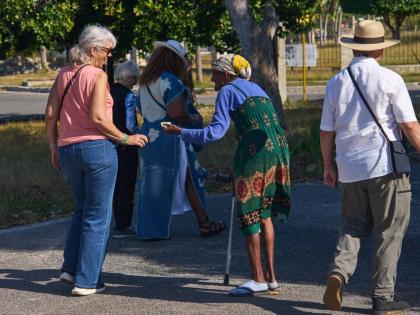 An elderly woman begs for alms from tourists in Havana, Cuba.