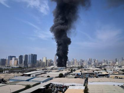 A black plume of smoke rises from a warehouse at the industrial area of Sharjah City in the United Arab Emirates following reports of Iranian strikes in Dubai, United Arab Emirates, Sunday, March 1, 2026. 