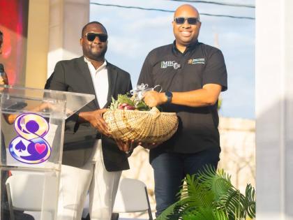 Richard Cole (left),chief executive officer of Level 8 – Bakery, Dining and Gaming Lounge, presents Delano Seiveright, state minister in the Ministry of Industry, Investment and Commerce, a basket containing St Elizabeth produce.