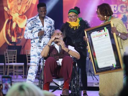 Kenneth Boothe (centre) is flanked by (from left) reggae artiste Romain Virgo, Queen of Reggae Marcia Griffiths, and Olivia Grange at the Reggae Gold Awards last Friday, as he receives his official plaque for induction into the Jamaica Music Museum