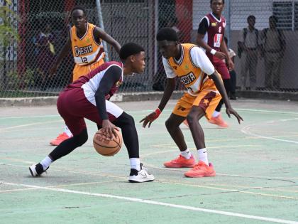 Herbert Morrison Technical High’s Antonio Kerr (left) tries to dribble around Manchester High’s Wasim Windett during Game One of the ISSA Schoolboy Under-16 Basketball finals at Herbert Morrison’s court on Monday.