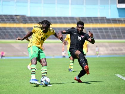 Trivante Stewart (left) takes a shot ahead of advancing Canadian Midfielder Alphonso Davies during a Concacaf Nations League game at the National Stadium in November 2023.