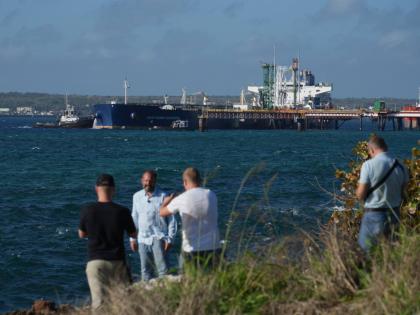 Journalists do a standup in front of the Russian-flagged oil tanker Anatoly Kolodkin docked in Matanzas, Cuba.
