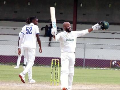 Jamaica Scorpions skipper John Campbell (right) celebrates scoring a century on the fourth day of the West Indies Championship cricket match against Barbados Pride at Chedwin Park, St Catherine, yesterday. Walking away is Barbados Pride paceman, Shamar Spr