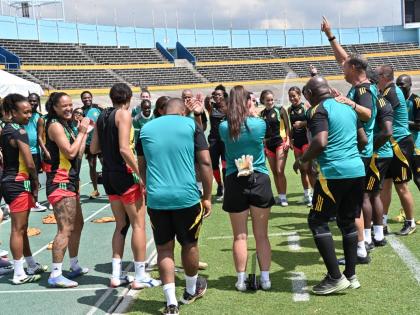 Reggae Girlz coach, Hubert Busby Jr (arm raised) rallies his troops during a training session at the National Stadium on April 17.