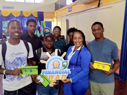 Kimblee Elliott, marketing officer at the Manchester Co-op Credit Union, takes a moment to pose with students at the Northern Caribbean University during the Reach & Teach School Tour.