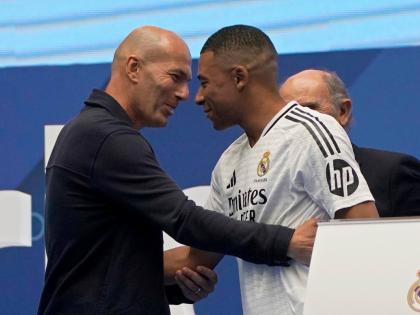 Former French player Zinedine Zidane (left) embraces Kylian Mbappe of France, as he is being presented to fans as a new Real Madrid player in Madrid on July 16, 2024. 