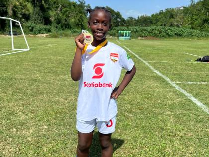 10-year-old Ricshi Scarlett proudly displays her first-place medal at the Scotia Kids Football Championships finals on May 31. The Rousseau Primary student discovered a passion for football after taking up the sport less than a year ago.