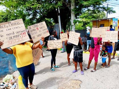 Placard-bearing residents stage a peaceful protest on Monday, demanding justice for Shemane Nugent.