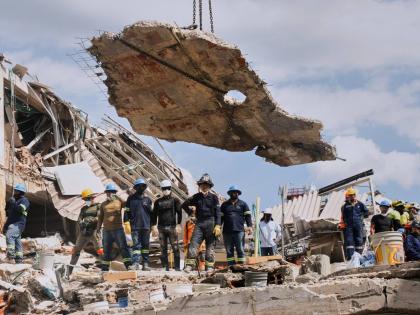 A crane lifts a concrete slab to clear the way for rescuers searching through the rubble three days after an earthquake hit Pereira, Colombia, Thursday, Aug. 13, 2026. (AP Photo/Brandon Pinto)