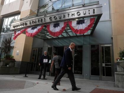 People walk outside of a Federal Courthouse Wednesday, Aug. 12, 2026, in Oakland, Calif. (AP Photo/Jeff Chiu)