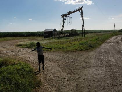 A youth plays near the machine where the sugar cane is weighed in the Lima batey, or neighborhood, in La Romana, where Central Romana Corporation, Ltd operates its sugar operations in Dominican Republic, November 17, 2021.