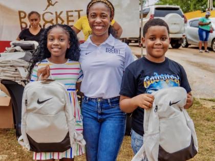 Shelly-Ann Fraser-Pryce (centre), founder and chairwoman of the Pocket Rocket Foundation, pauses for a photo with Jahvena Eaton (left) and Antwan Ellis during the foundation’s annual back-to-school treat, held on Monday, August 10, in Ewarton, St Catheri