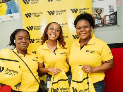 From left: GraceKennedy Money Services (GKMS) team members Vanessa Gilbert, Abigail Burt and Vanessa Lyons prepare to distribute back-to-school care packages to customers at GKMS East Parade during the One More Step Location Tour. Through the initiative, G