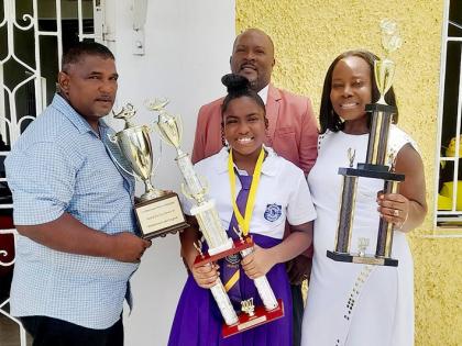 Gabrielle Dajue (centre) with her parents, Robert Dajue (right) and Phillipea Dajue, while Crescent All-Age School Principal Harris Francis stands in the background. 