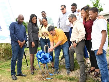 Minister of Water, Environment and Climate Change, Matthew Samuda (centre), turns on a pipe to officially commission the Spring Garden Water Supply System in St James on Wednesday. Looking on are Mayor of Montego Bay and Chairman of the St James Municipal 