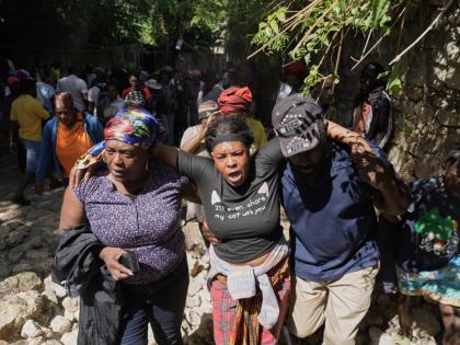 People watch as the bodies of their relatives who were killed in a gang attack are carried away by morgue workers in the Kenscoff neighbourhood of Port-au-Prince, Haiti, on Monday.