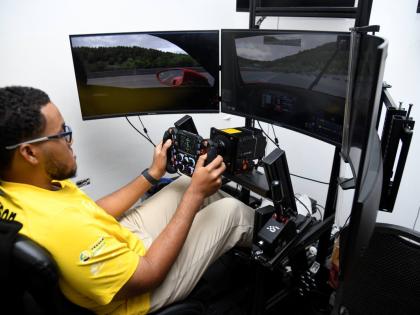 Jayden Harrison, professional simulation racer for S Hotel’s team Jamaica gives a demonstration of the driving simulation at a press conference at S Hotel yesterday. 