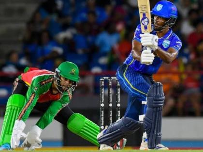Guyana Amazon Warriors wicketkeeper Shai Hope (left) watches as Ackeem Auguste goes on the attack during a Caribbean Premier League game.