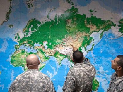 Soldiers look at a world map as they wait to board a flight in Manas, Kyrgyzstan, on the way home after completing a deployment in Afghanistan, Thursday, August 11, 2011. (AP Photo/David Goldman, file)