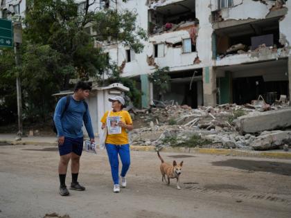 Pedro Gomez (left) walks through La Guaira, Venezuela, with a friend, asking people if they have seen his cousin, Andres Molina.