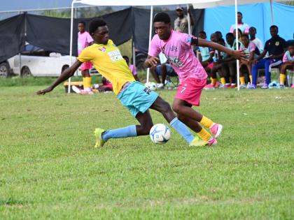 Rusea’s High’s Maliek Headed (right) skips by the challenge of Little London High’s Clifton Cameron during their ISSA daCosta Cup first-round football game at the Little London playing field on Saturday.