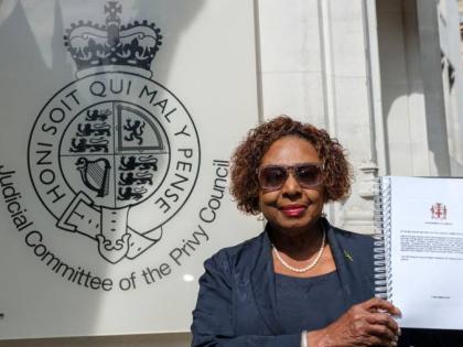 Culture Minister Olivia Grange stands in front of the Judicial Committee of the Privy Council building in London, England, holding the historic reparations petition document filed to King Charles III.