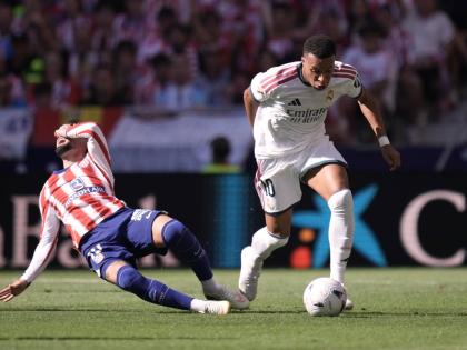 Atletico Madrid’s Alex Baena (left) falls to the ground in a clash with Real Madrid’s Kylian Mbappe during a Spanish La Liga football match in Madrid on Sunday.