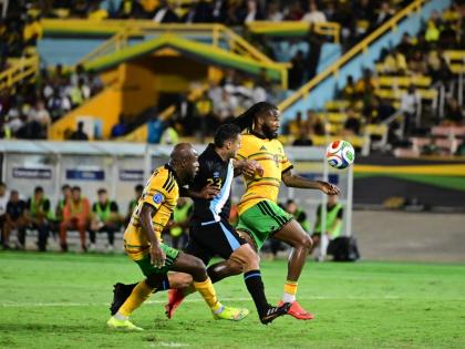 Reggae Boyz Javon East (left) and Kasey Palmer flank Guatemalan midfielder Jorge Aparicio during a Concacaf Nations League encounter at the National Stadium on Friday night.