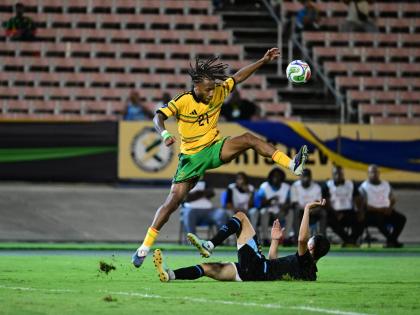
Reggae Boy Rumarn Burrell hurdles a challenge during a Concacaf Nations League football match against Guatemala at the National Stadium on Friday night.