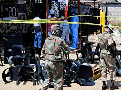 Forensic officers and the army members are seen at scene of a mass shooting on Saturday night when suspects opened fire at a bar in Wedela township, southwest of Johannesburg, South Africa, Sunday, Sept. 27, 2026. (AP Photo)