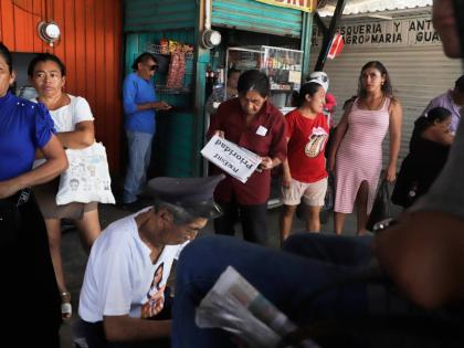 A person reads a newspaper at a market in Campeche, Mexico, on September 17.