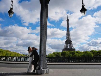 Tourists walk past the Eiffel Tower after it reopened following a one-day strike over restrictions on women during a visit by a Hindu delegation in Paris on September 8.