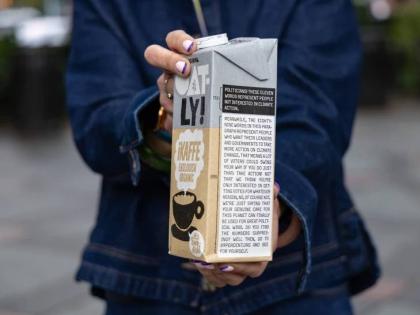Caroline Reid, with the Swedish oat milk company Oatly, shows a sample of the company’s new milk carton climate campaign for New York Climate Week on Wednesday, September 23 in New York. 