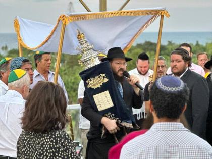  
Rabbi Yaakov Raskin joins the singing and dancing during the traditional procession welcoming a newly handwritten Torah scroll to Chabad of Jamaica.