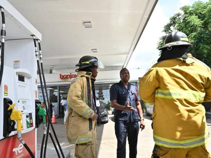 District Officer Shaun Grant of the Jamaica Fire Brigade greets firefighters from the unit which responded to TotalEnergies fire-simulation drill at its Manor Park Service Centre on September 24. Grant and Acting Sergeant Lecia Oliver, along with Terry Fos
