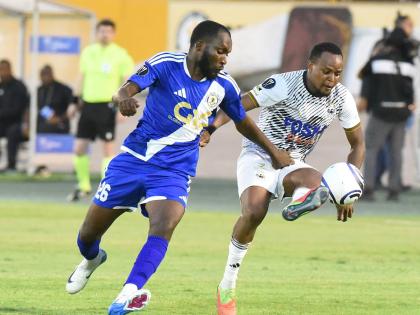 Nicholas Hamilton (right) of Cavalier  is challenged for the ball by Mount Pleasant’s Clifford Thomas during their Concacaf Caribbean Cup football match at the National Stadium in September.